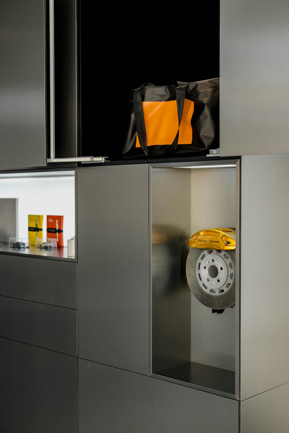 A yellow brake caliper displayed on a shelf in a store.